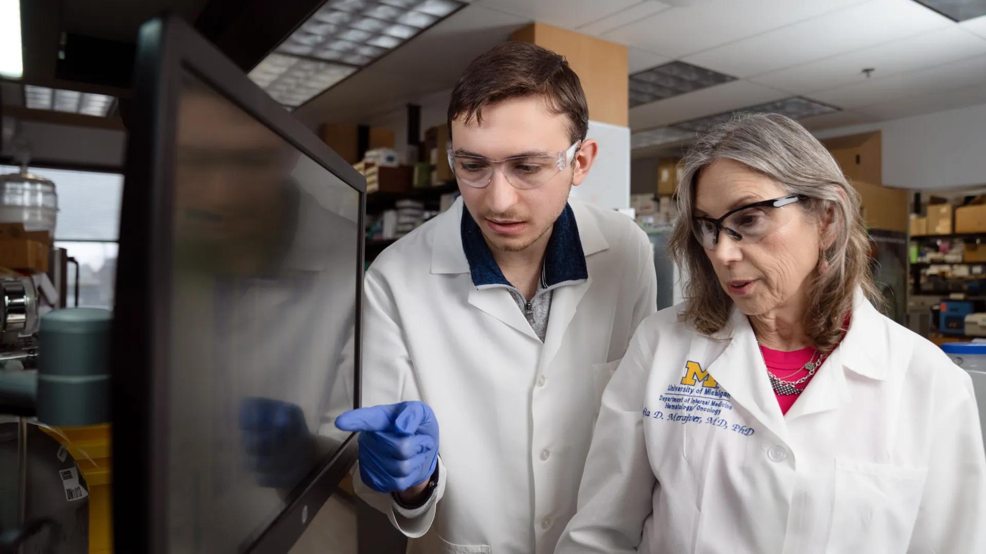 Dr. Sofia Merajver and a lab technician look at a computer screen