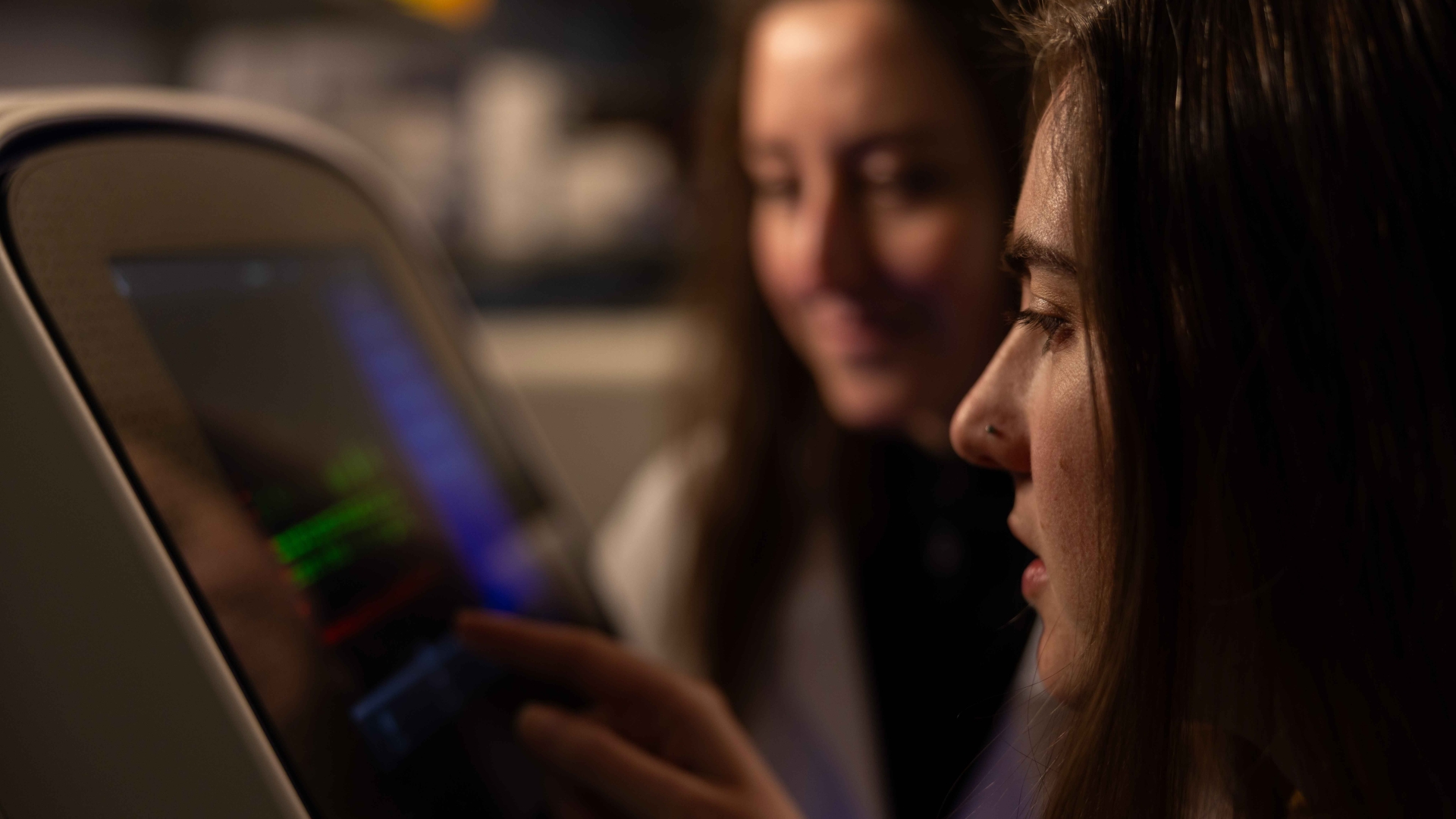 Lab members working with lab equipment and looking at a screen