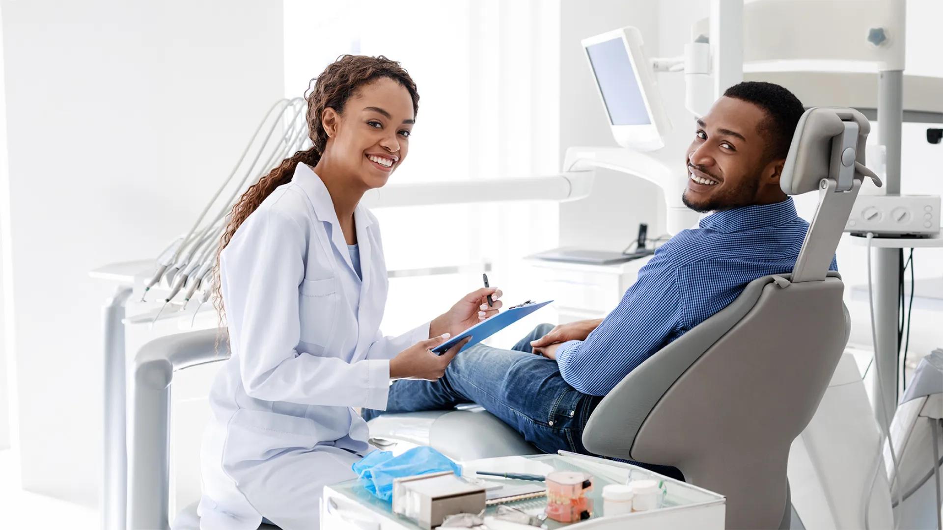 dentist and patient smiling at the camera