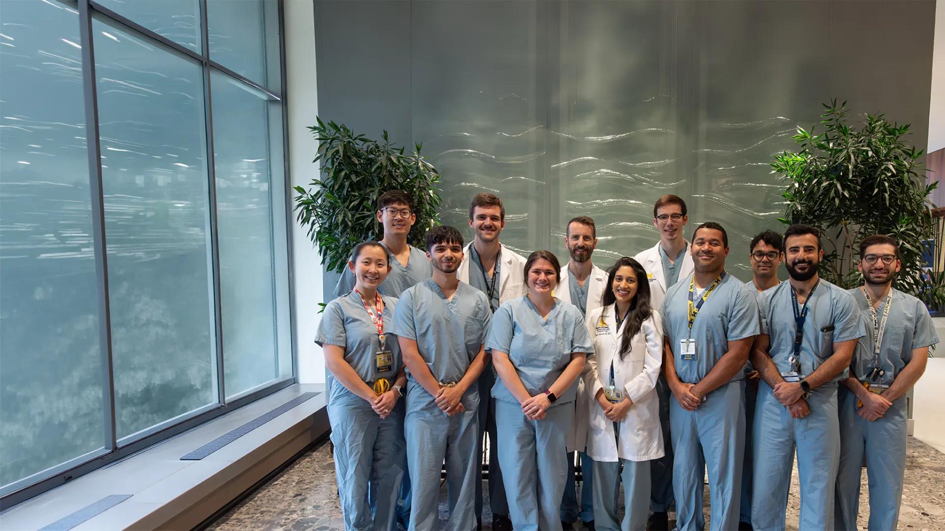 group of people posing for a photo wearing lab coats and scrubs