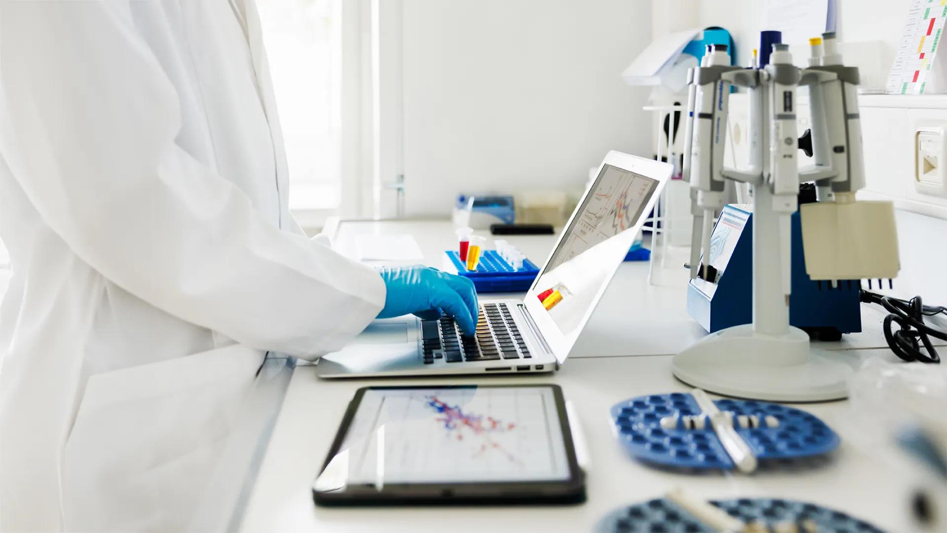 close-up of researcher working in lab on a computer