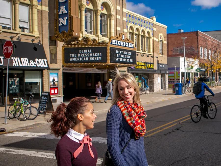 Two people crossing the street in downtown Ann Arbor