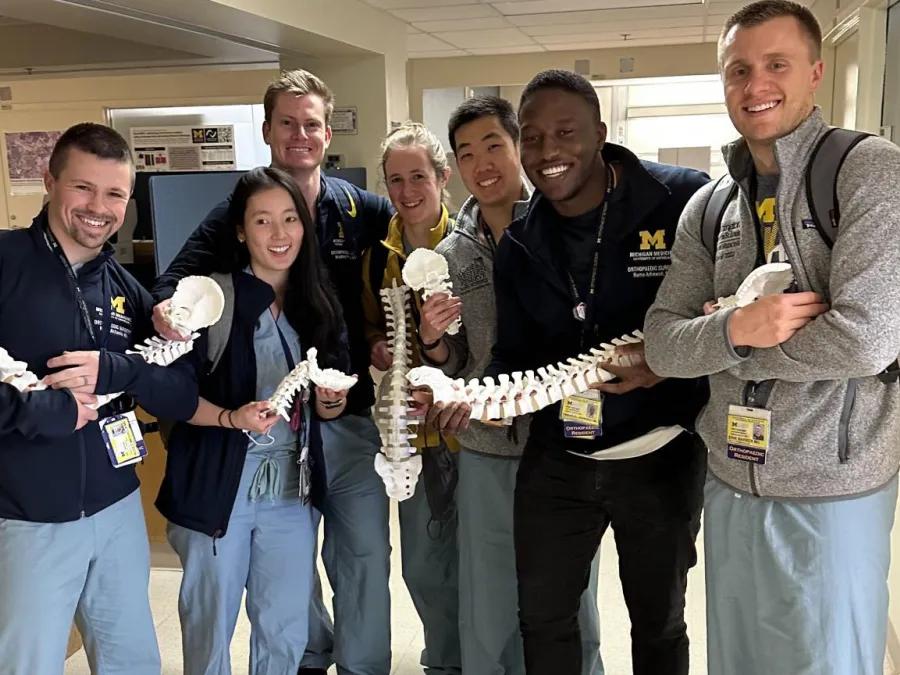 resident group photo all holding parts of a practice skeleton