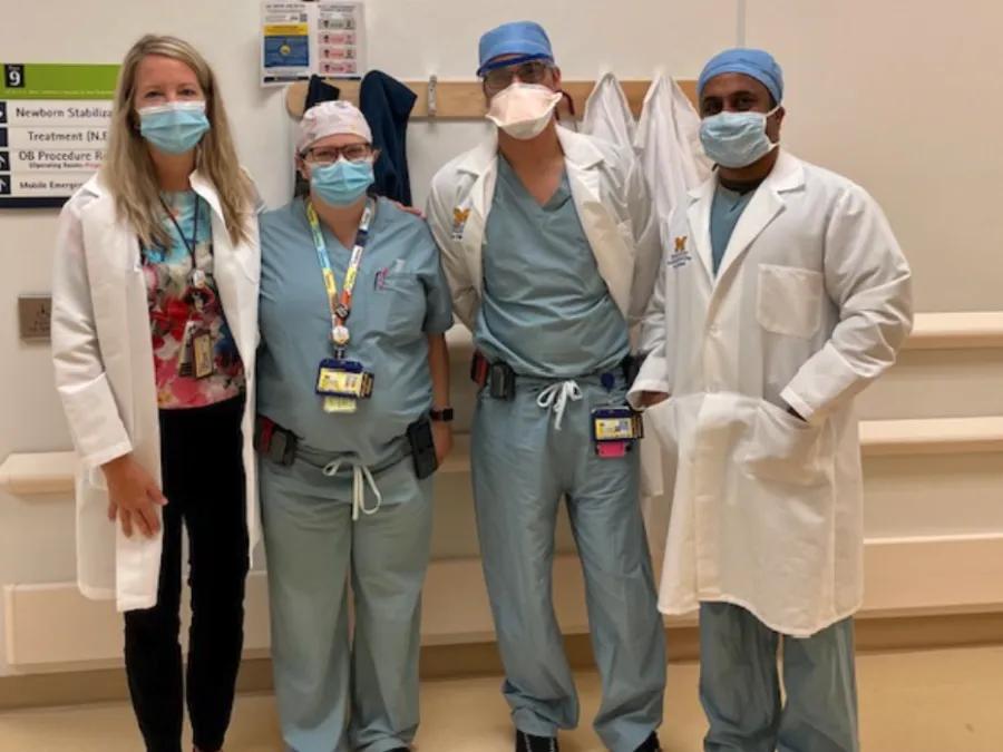 Four anesthesiologist standing together wearing masks and in scrubs 