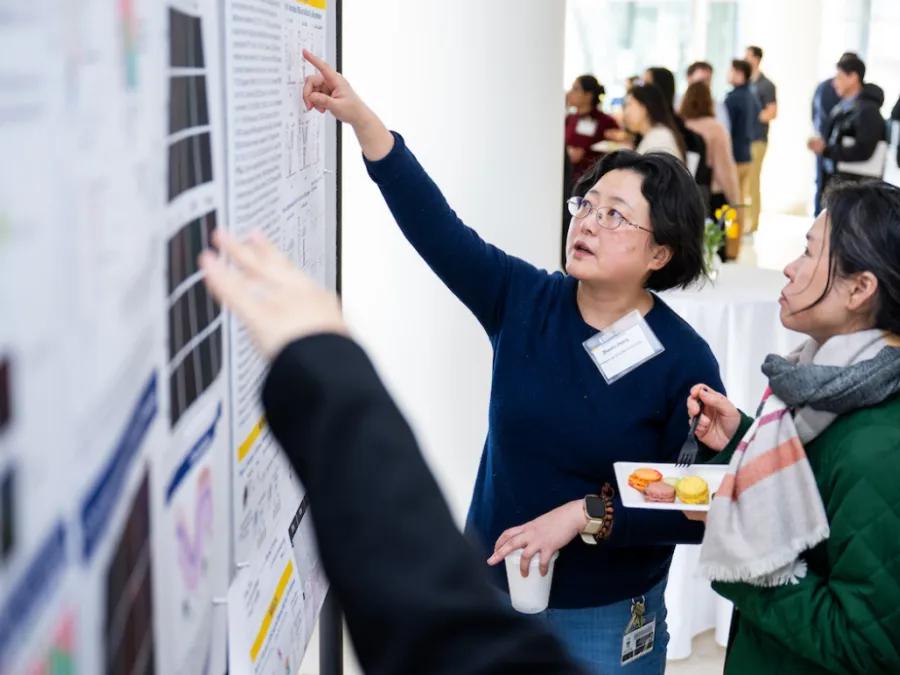 Dermatology researchers look at a poster