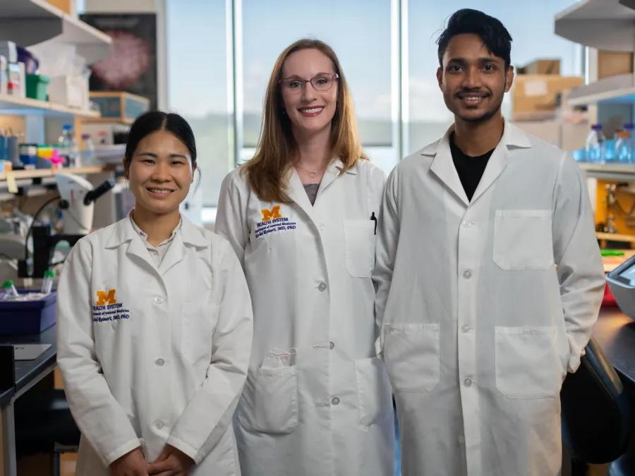 three young researchers posing for photo in research lab