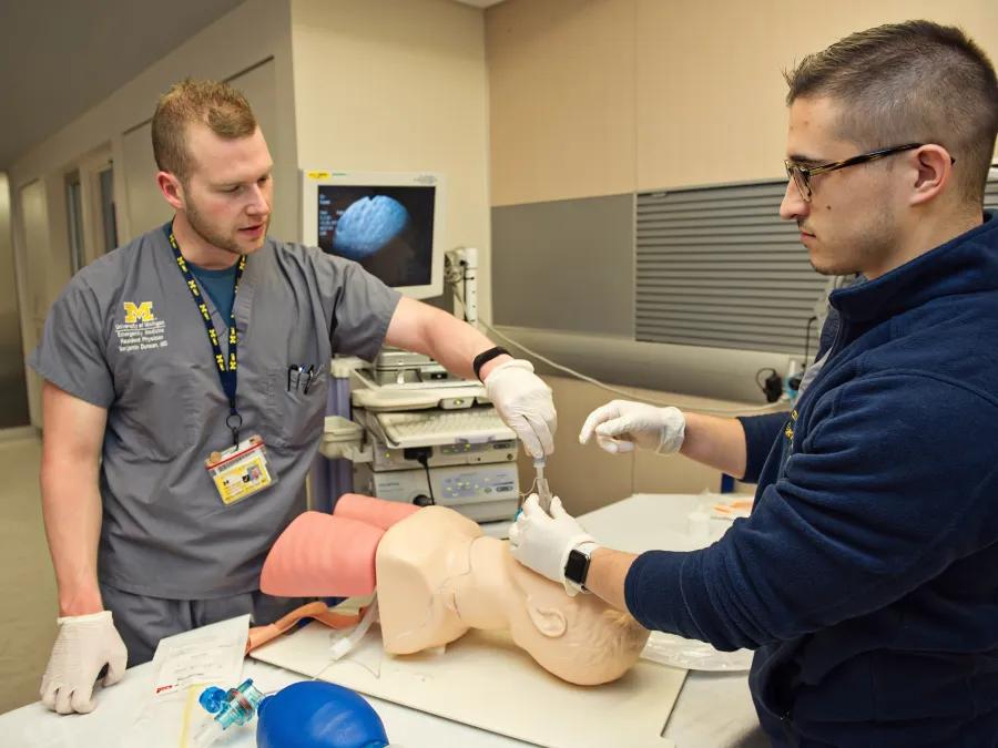 residents using medical tools in simulation 