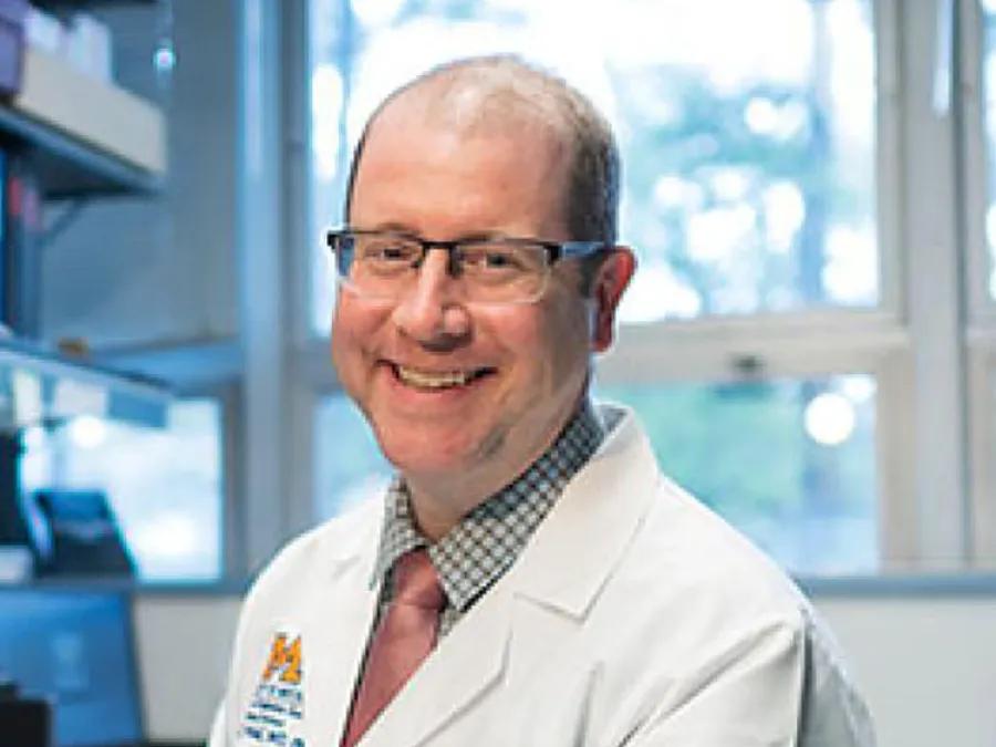 Smiling portrait of Dan Wahl, M.D., Ph.D., seated in his laboratory/