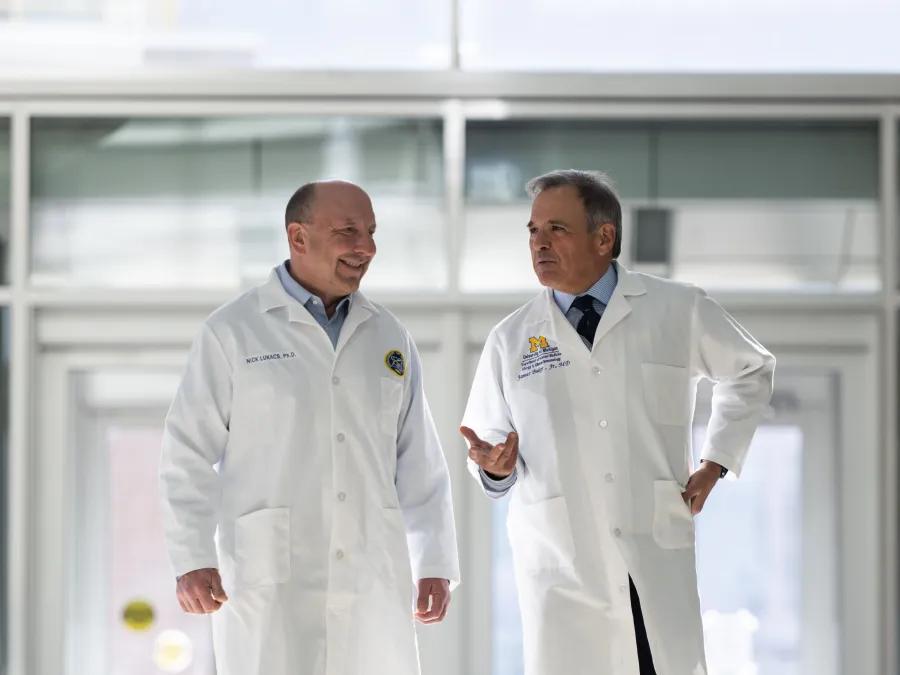 Food allergy scientists in white coats walking in atrium 