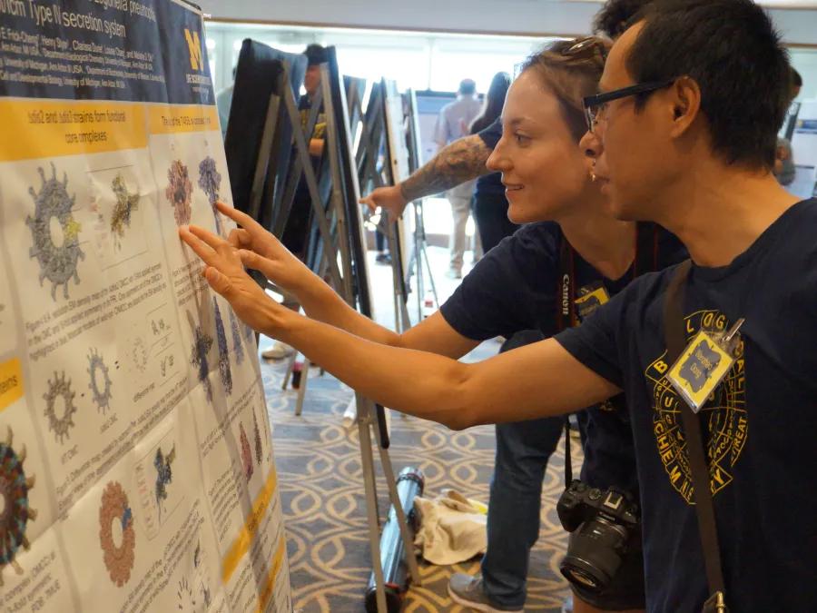 Scientists engaged in discussion at a research poster