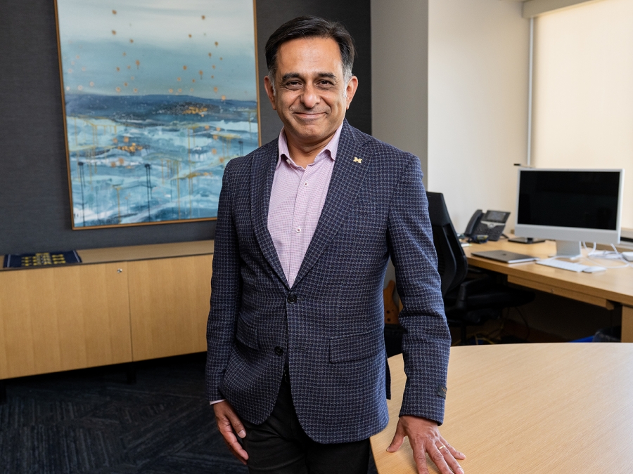 Chair Vikas Gulani smiles for a photo at his desk