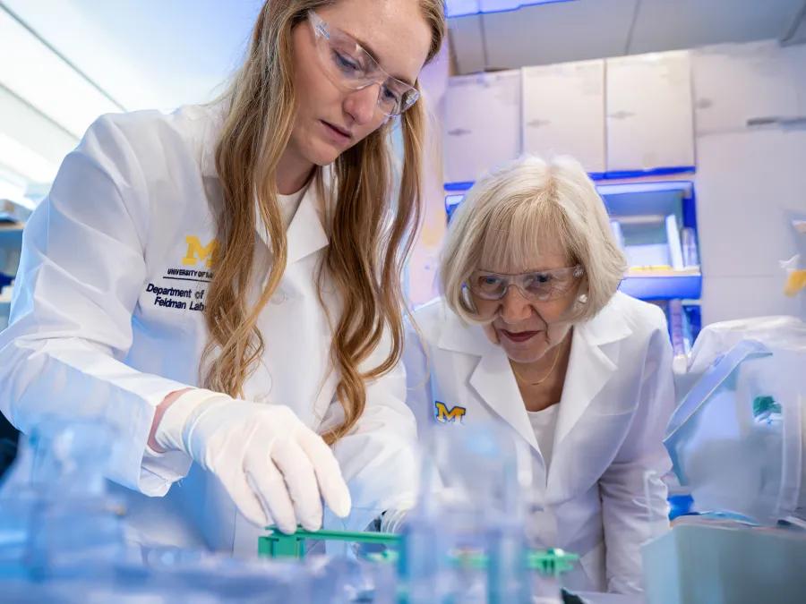 Drs. Cali McEntee and Eva Feldman looking at test tubes in the lab