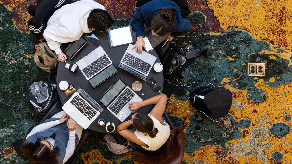 Fellows working around a table with their laptops
