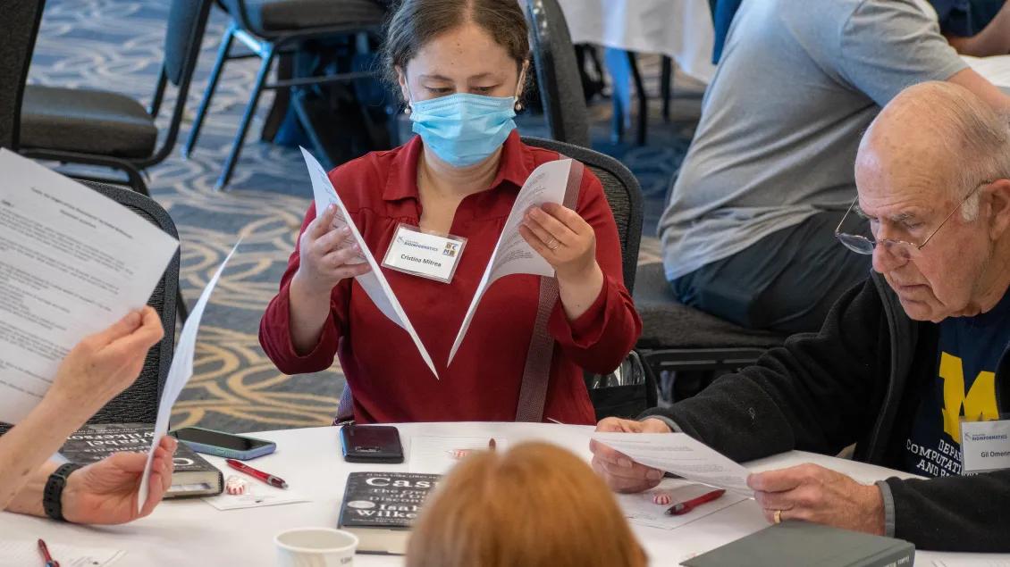  woman in red shirt reads through papers