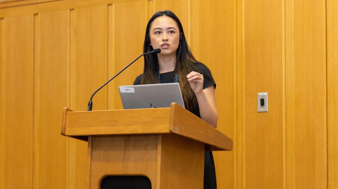  woman gives speech at podium for obgyn research day 