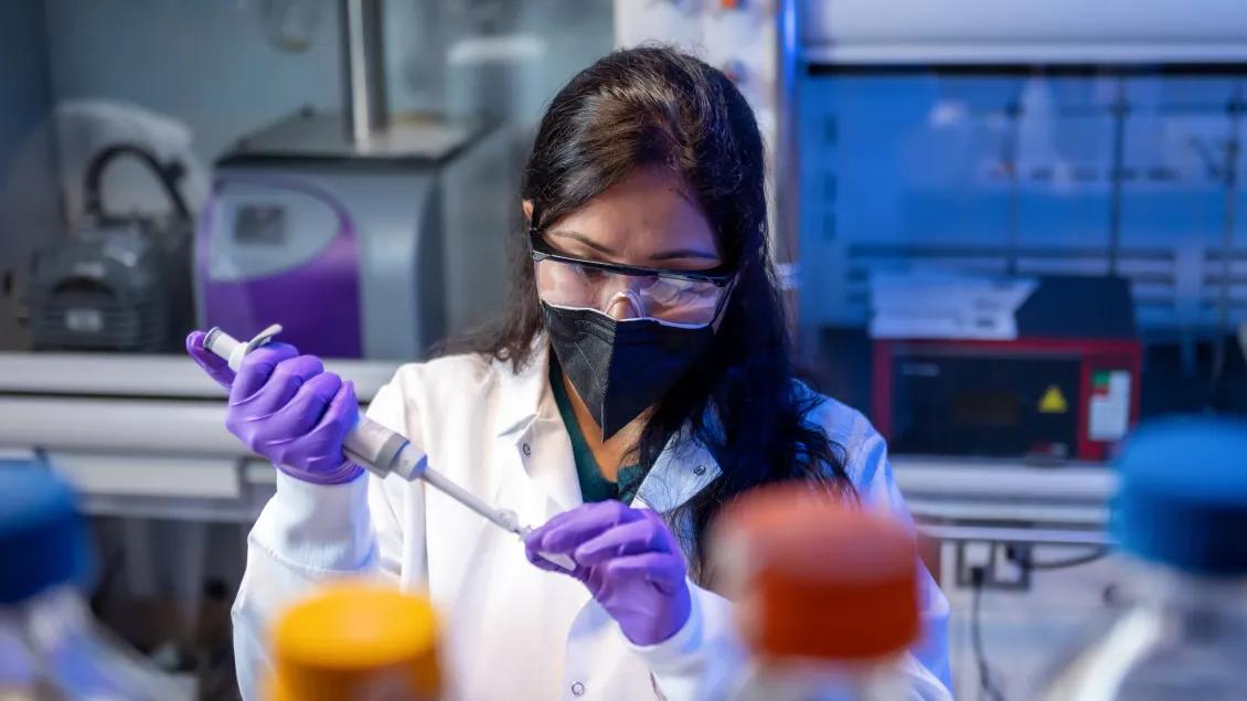 researcher in a lab wearing a mask