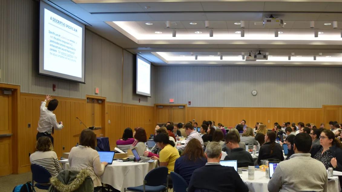man presenting to a room full of event attendees