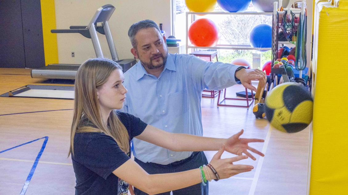 doctor performing exercises with medicine ball on wall