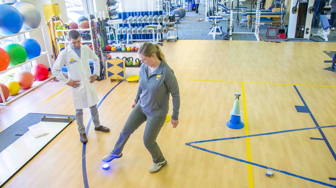 patient completing toe touch response time trying while doctor observes 