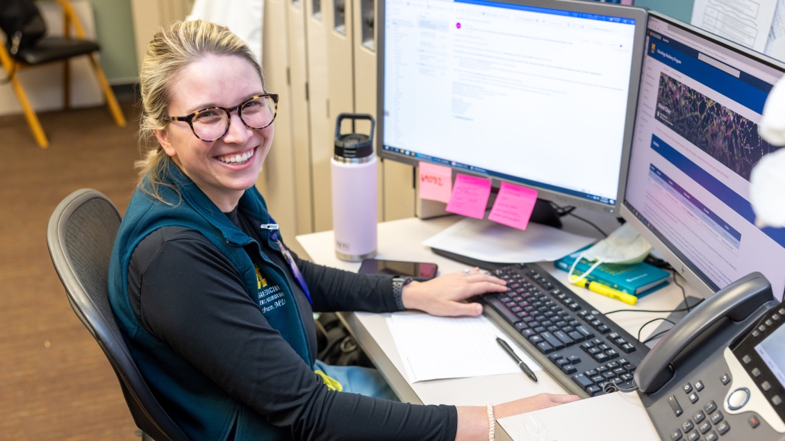 Woman sits at computer to monitor sleep movement disorder patients 