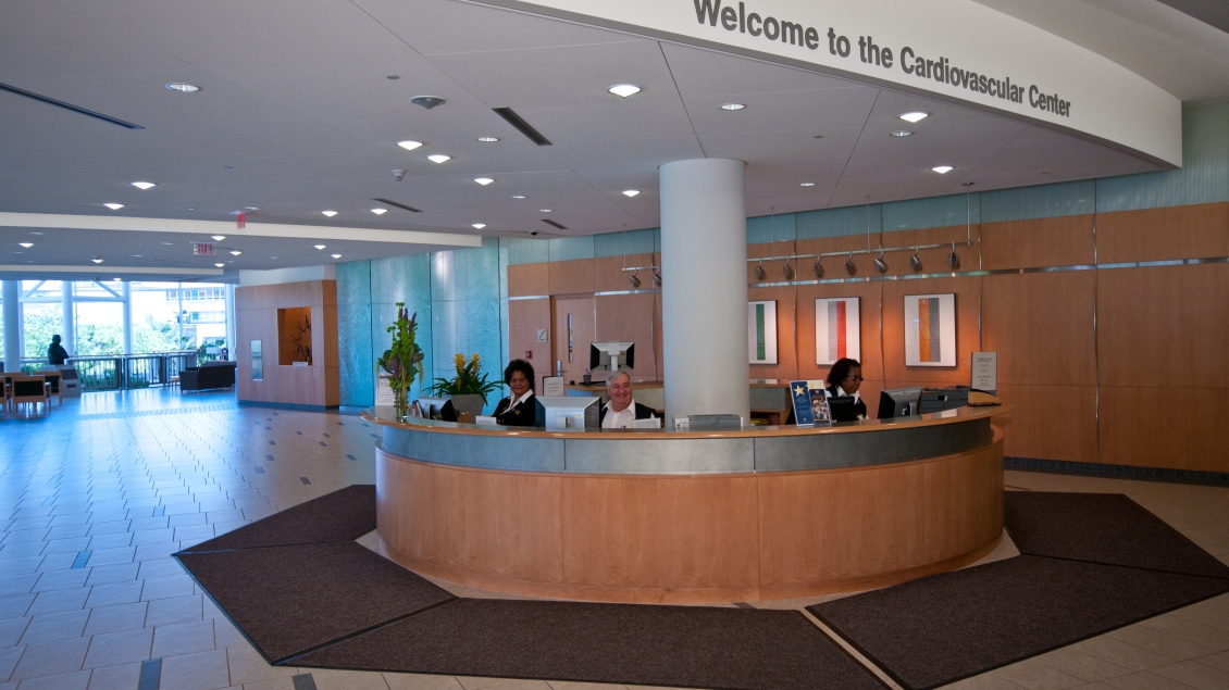 Three greeters sit at the large circular CVC welcome desk