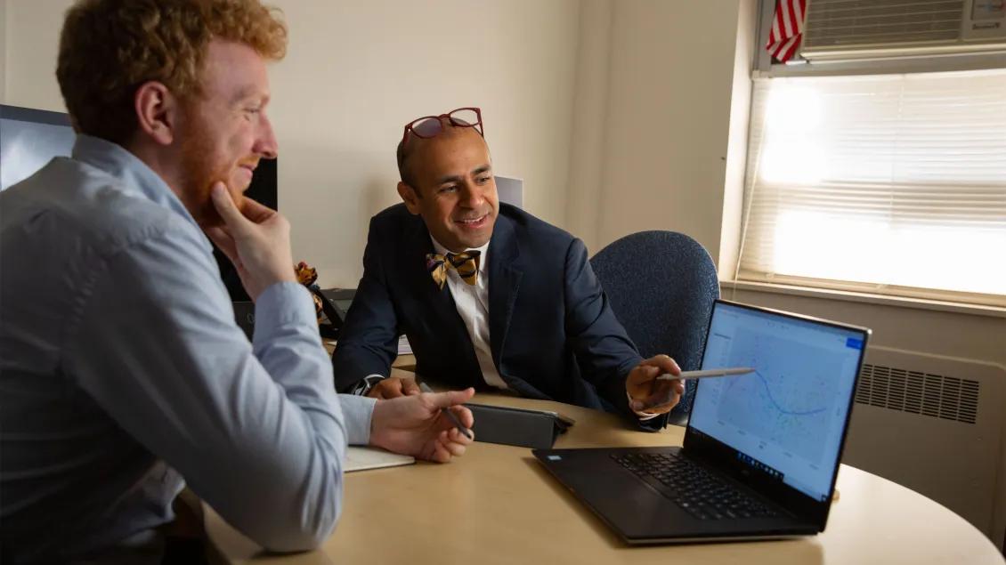 Dr. Uppal meeting with a learner and looking at a laptop together