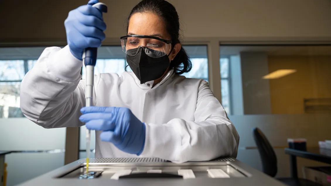 woman in lab holding advanced genomics technology