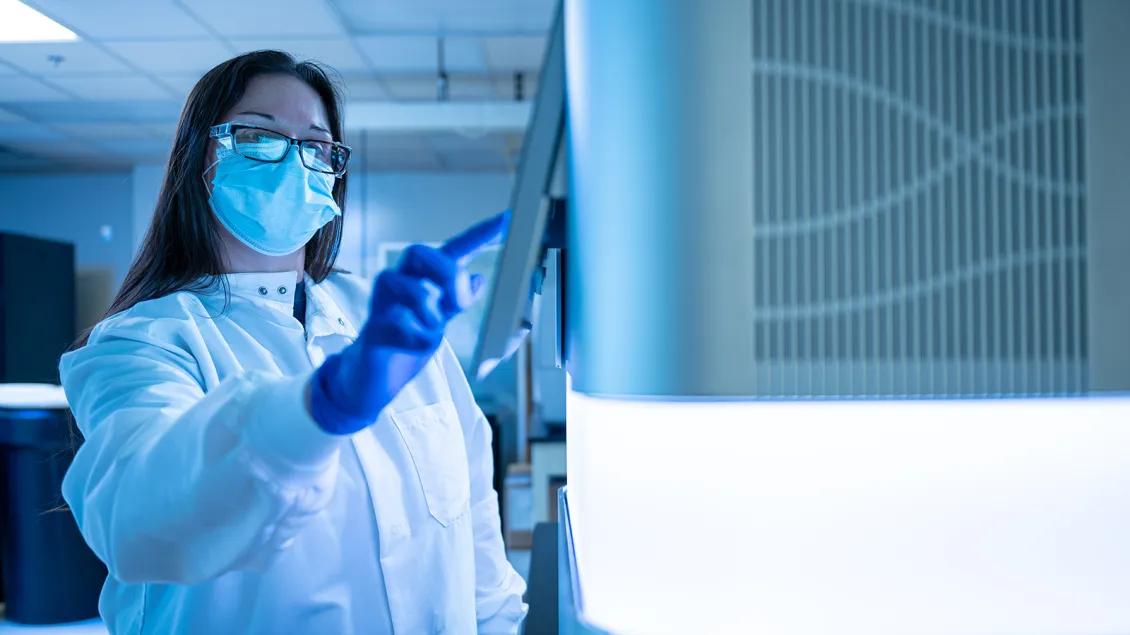 woman touching Next Generation Sequencing technology machine
