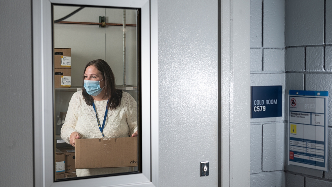 woman in cold room carrying box