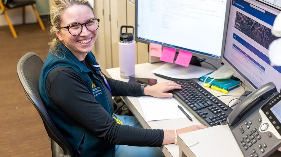Photo of a female study team member sitting in front of a computer