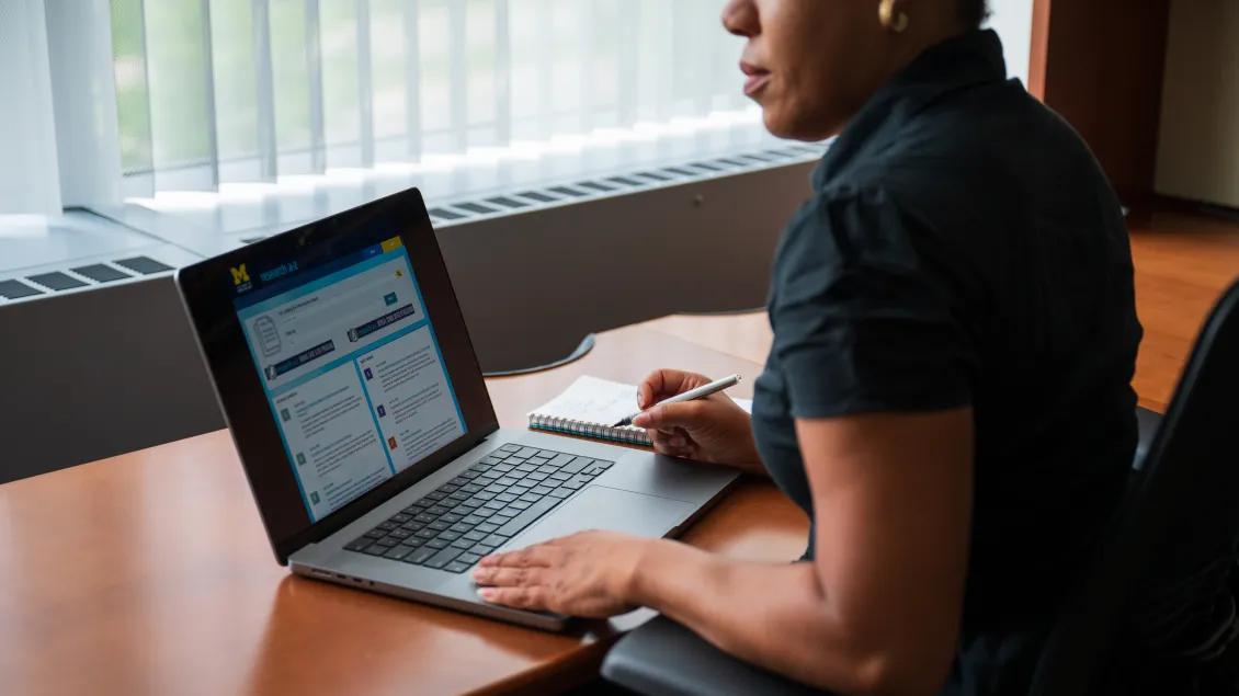 Photo of a woman sitting in front of a computer that has Research A to Z on the screen