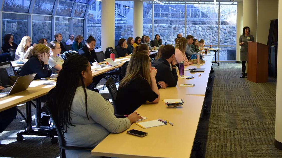 filled room of people watching presentation