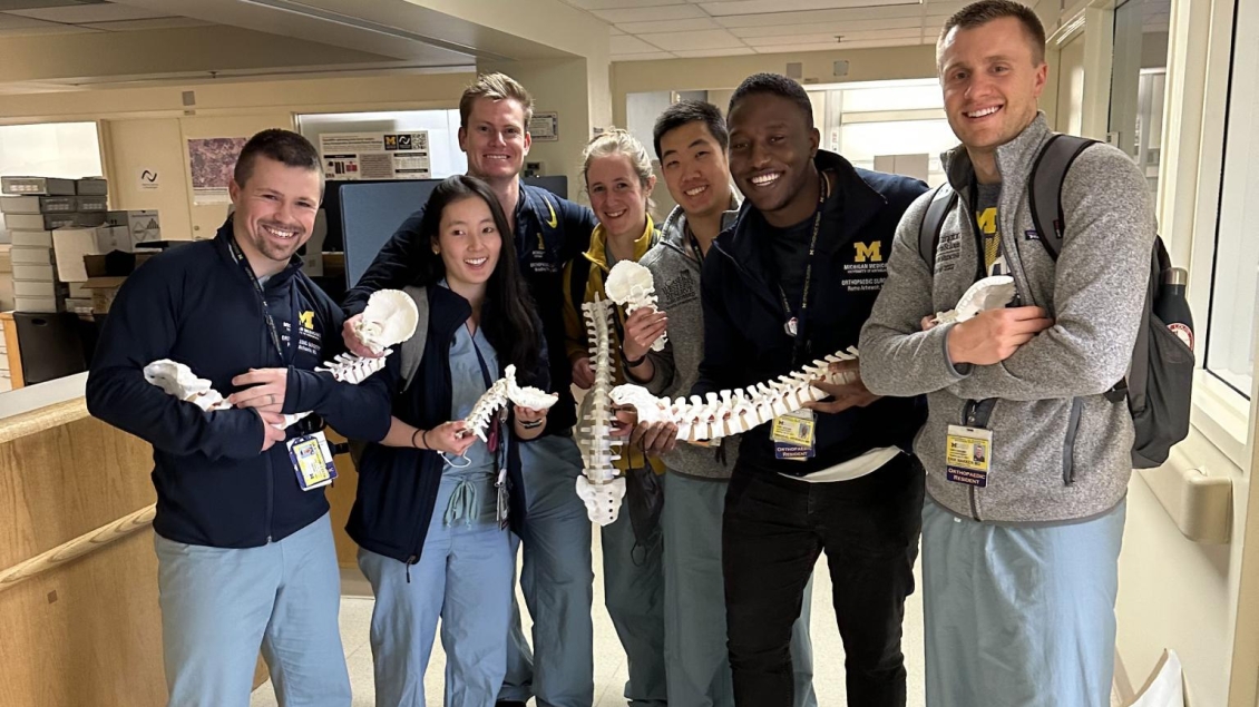 resident group photo all holding parts of a practice skeleton