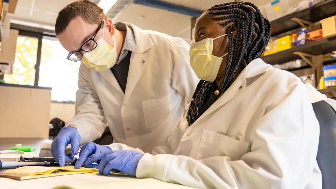 two researchers discussing paperwork in lab