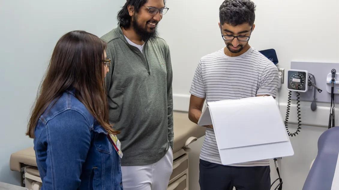 three young researchers looking over paperwork