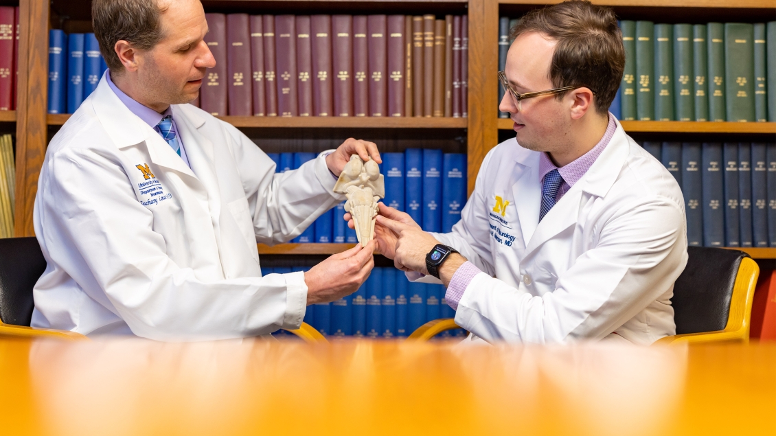 two researchers holding medical model