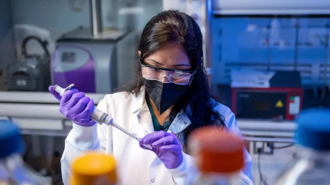 A dermatology researcher works in the lab