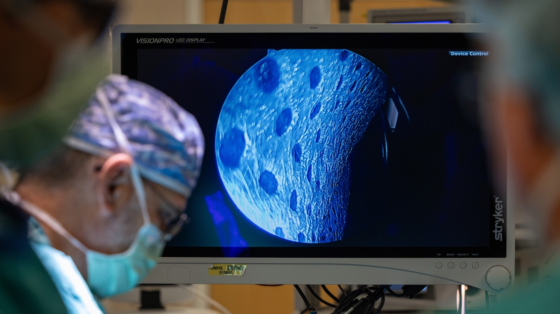 a person in scrubs and surgical gear looking at a screen