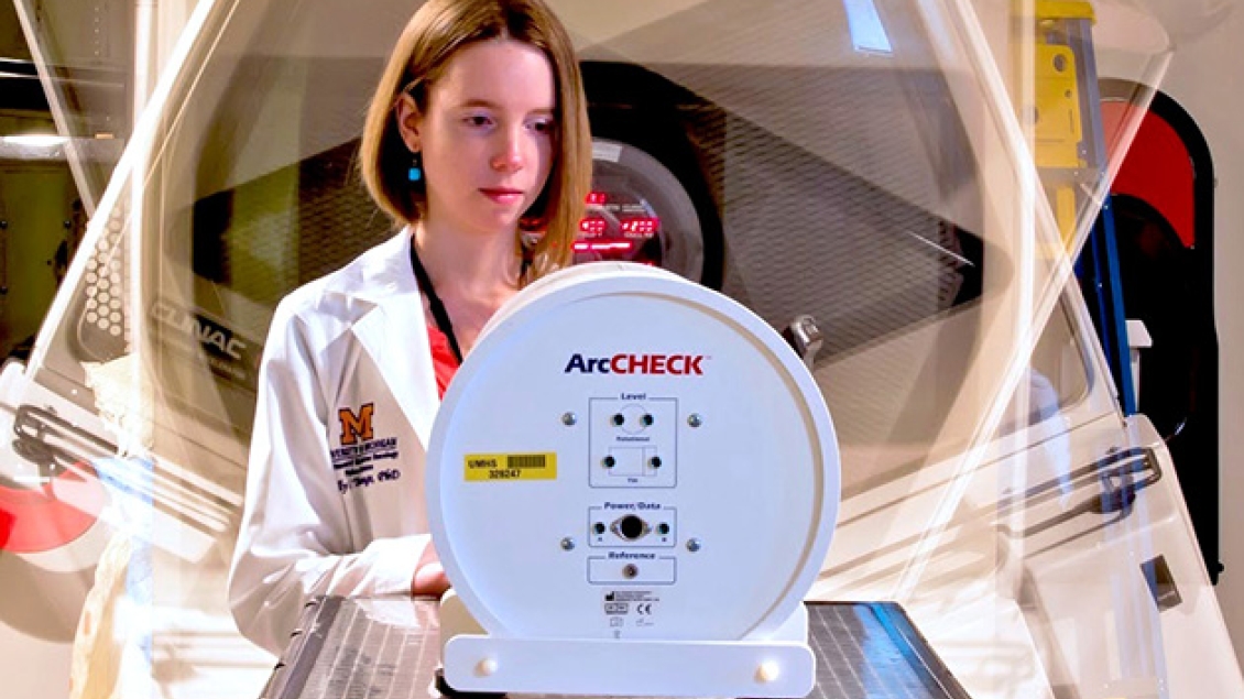 Radiation Oncology resident works in the lab at a machine