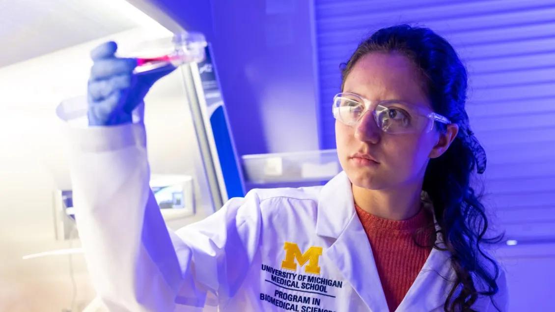 A female researcher examines a petri dish