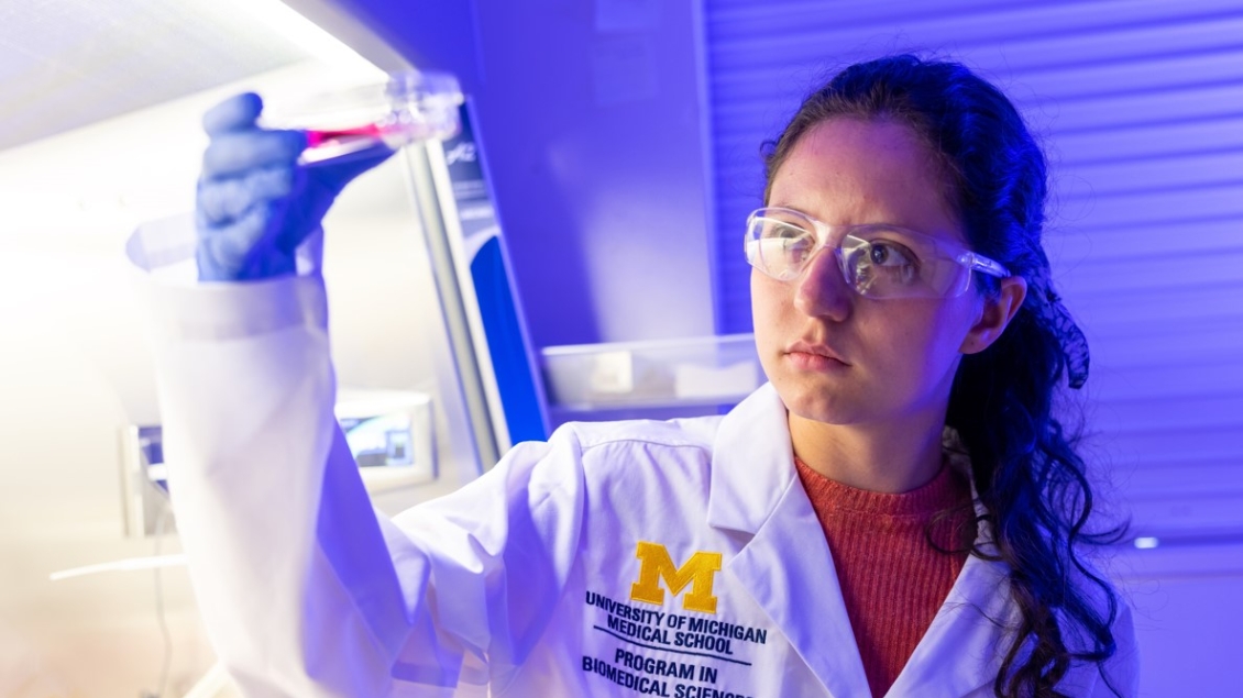 A female researcher examines a petri dish