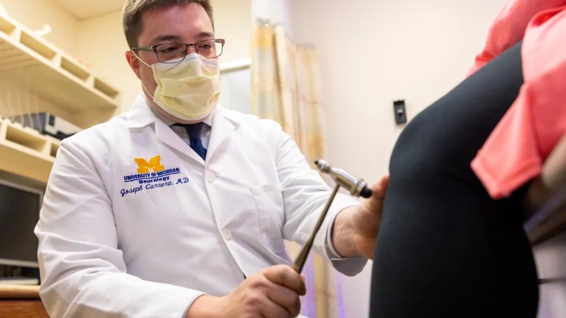 Dr. Carrera tests a patient's knee reflexes