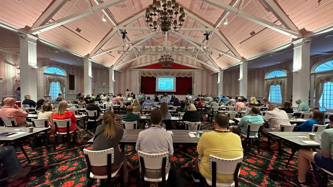 CME learners sit in an event center for a presentation