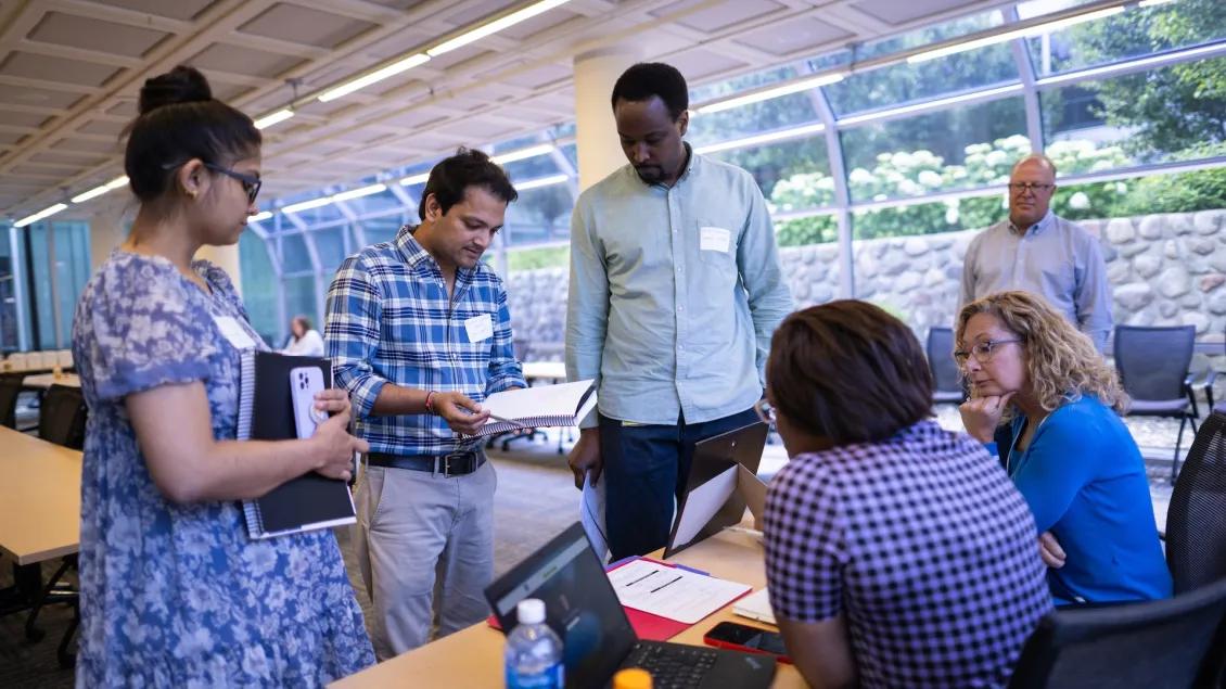 Attendees gathered around a table at an event in the South Atrium at NCRC