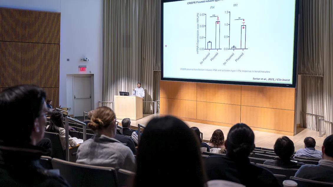 Man lecturing to an auditorium of people