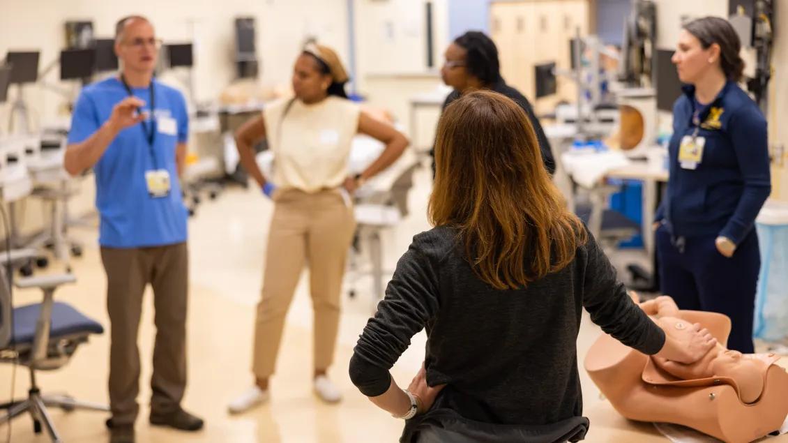 A group of students listening to a lecture in an exam room