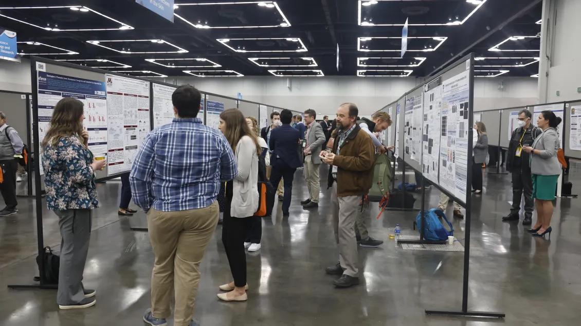 Multiple people viewing scientific posters in an exhibition hall