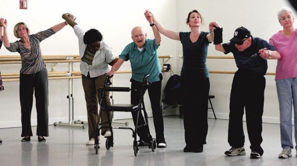 A group of Parkinson's patients dance with their instructor