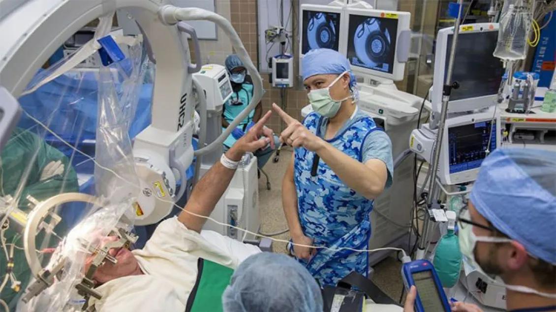 A research subject reaches out and touches the clinicians finger