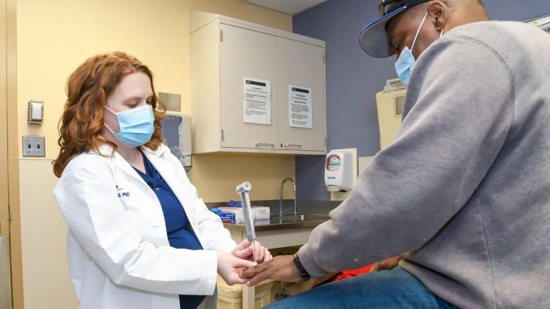 photo of Dr. Melissa Elafros checking a patient for signs of diabetic neuropathy